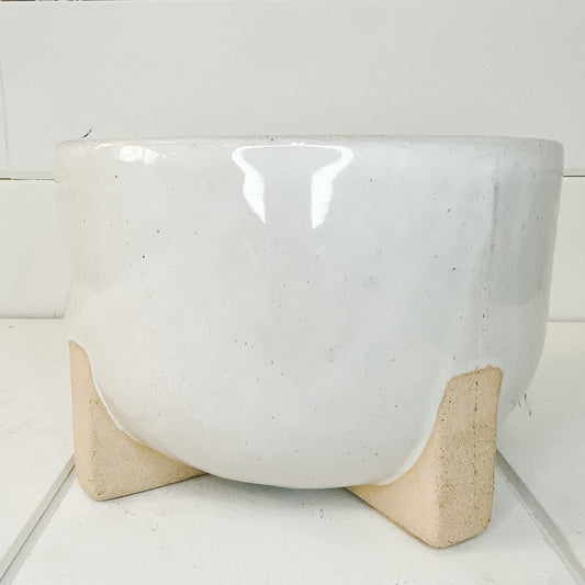 Ivory ceramic planter with feet.
