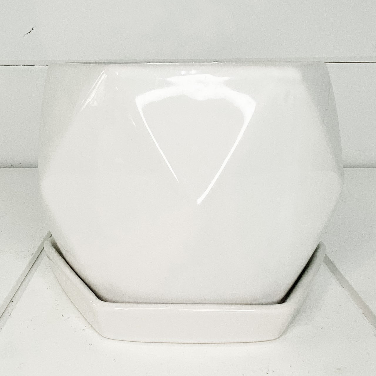 White hexagonal ceramic pot with saucer