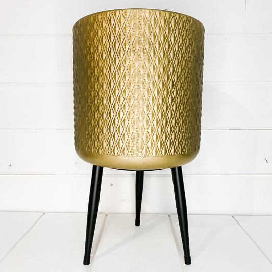 Gold metal planter on legs.