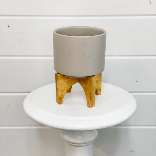 Speckled grey plant pot on wood stand